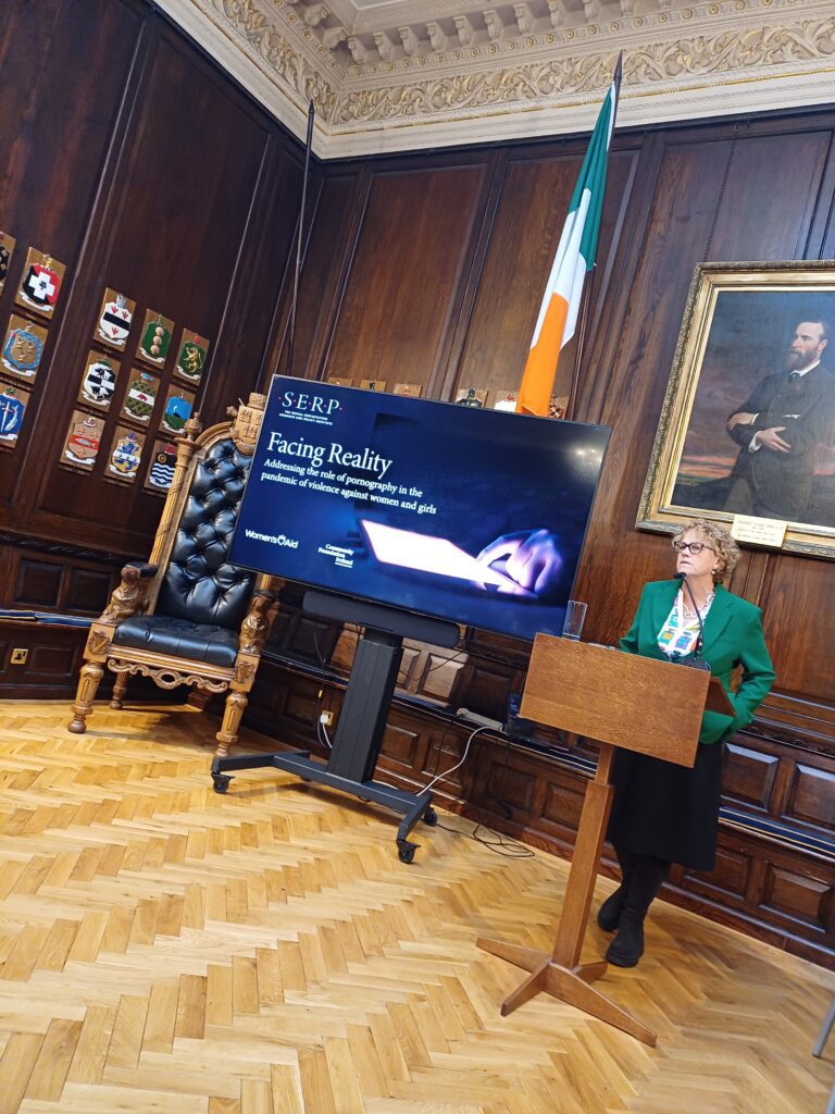 Denise Charlton addressing the loss at the Oak Room in Dublin's Mansion House. Standing at podium with Irish National Flag in background